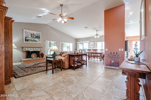 living room with ceiling fan, high vaulted ceiling, and a tiled fireplace