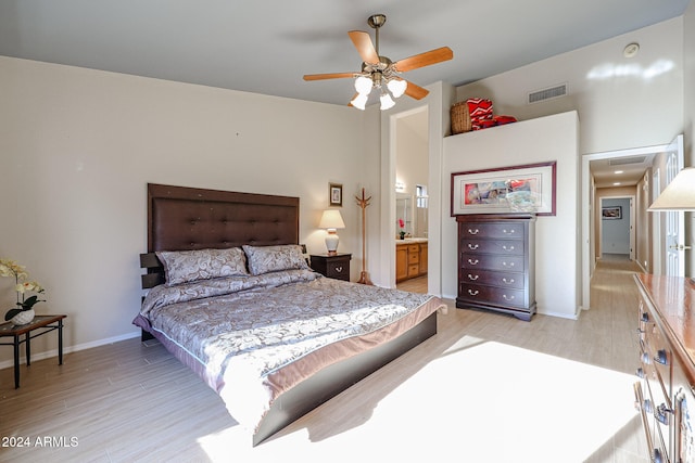 bedroom featuring ensuite bath, ceiling fan, and light wood-type flooring