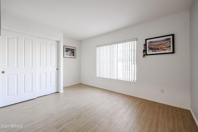 unfurnished bedroom featuring a closet and light hardwood / wood-style flooring