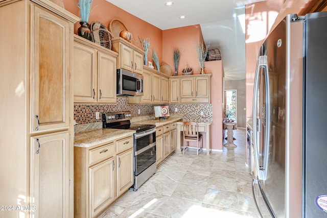 kitchen with light brown cabinets, backsplash, stainless steel appliances, and light stone counters