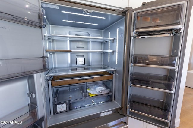 interior details featuring hardwood / wood-style flooring and refrigerator