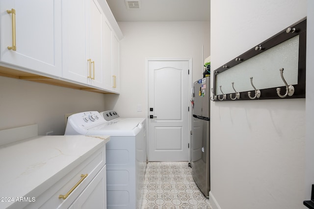 laundry area featuring washer and clothes dryer and cabinets