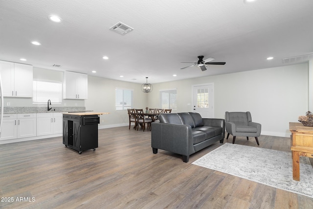 living room with ceiling fan, sink, a textured ceiling, and hardwood / wood-style flooring