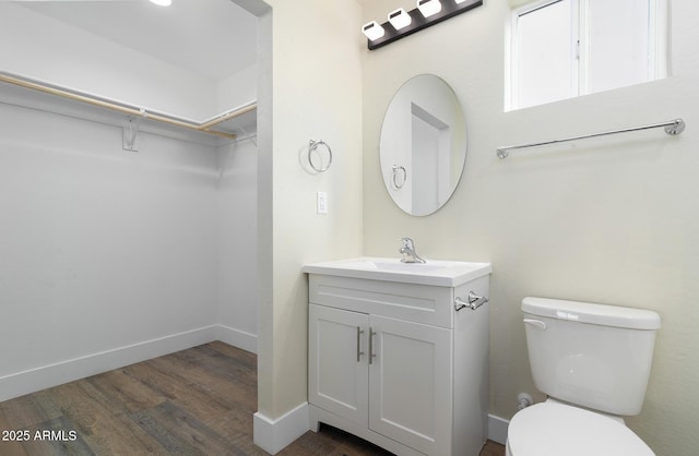 bathroom with wood-type flooring, vanity, and toilet