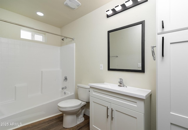 full bathroom featuring washtub / shower combination, vanity, hardwood / wood-style flooring, and toilet