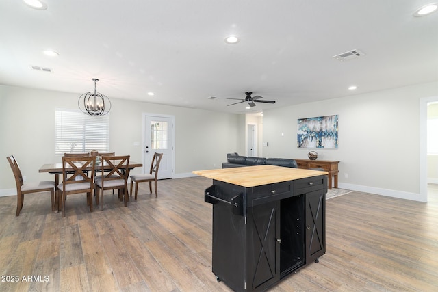 kitchen featuring a center island, wooden counters, decorative light fixtures, ceiling fan with notable chandelier, and light wood-type flooring