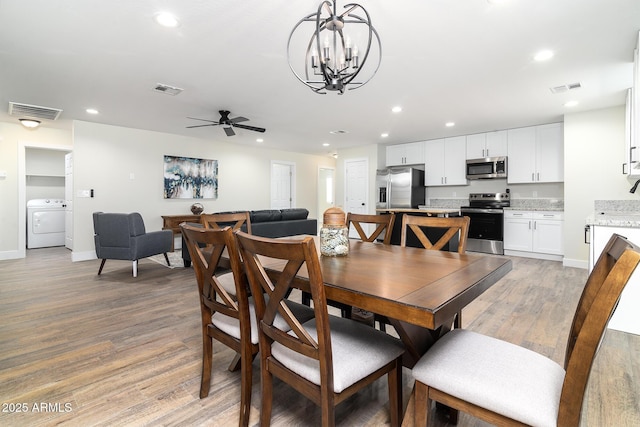 dining room featuring washer / clothes dryer, light hardwood / wood-style floors, and ceiling fan with notable chandelier