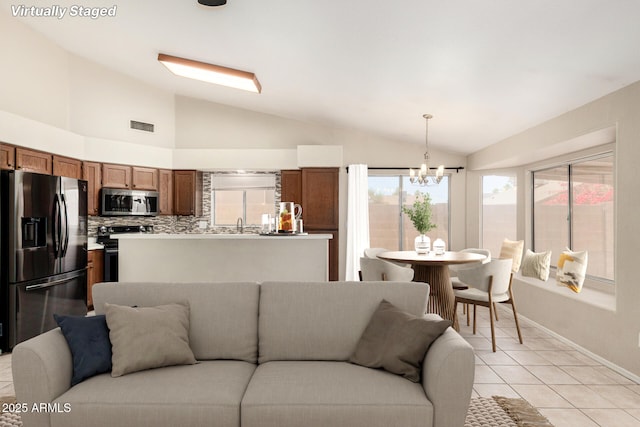 6317 E Colby St, Mesa, AZ 85205 - living room featuring vaulted ceiling, a chandelier, light tile patterned flooring, plenty of natural light, and baseboards