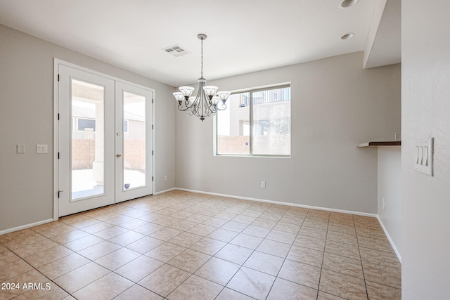 spare room with a chandelier, visible vents, baseboards, french doors, and tile patterned floors