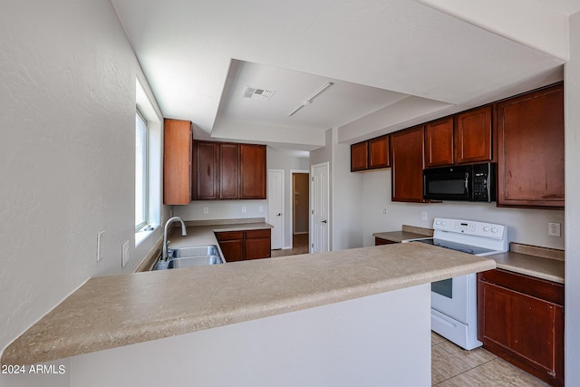 kitchen featuring electric range, visible vents, a peninsula, black microwave, and a sink