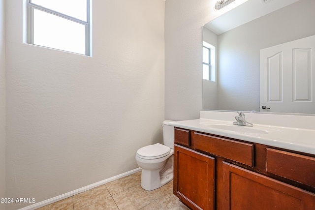 bathroom featuring baseboards, vanity, toilet, and tile patterned floors