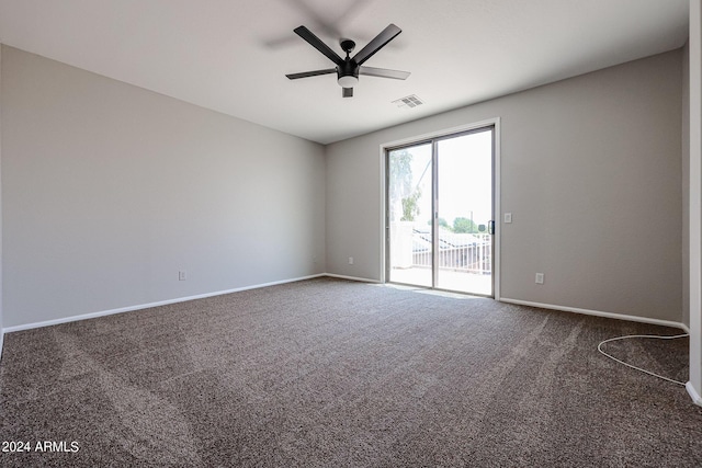 carpeted spare room featuring visible vents, ceiling fan, and baseboards