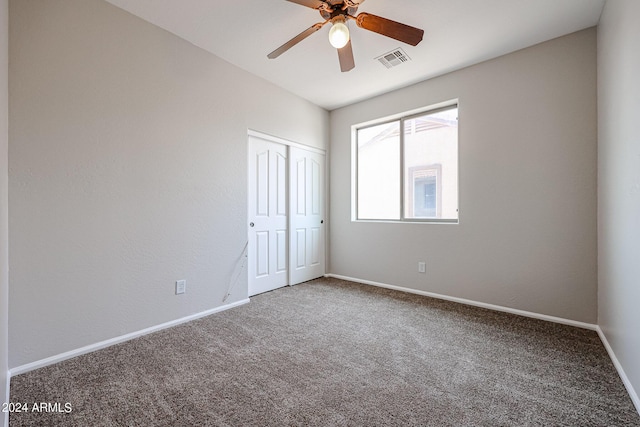 unfurnished room with carpet floors, a ceiling fan, visible vents, and baseboards