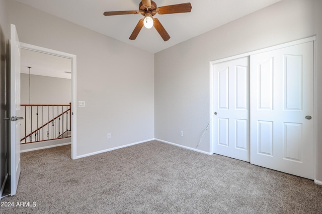 unfurnished bedroom with ceiling fan, carpet floors, a closet, and baseboards