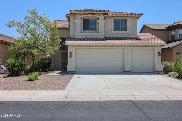 mediterranean / spanish home with concrete driveway, a tile roof, and stucco siding