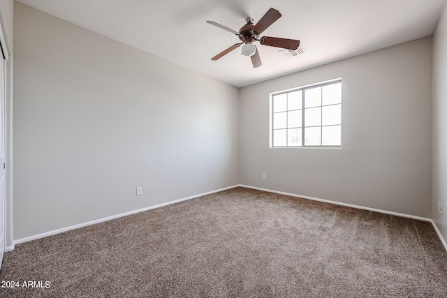 spare room featuring carpet, visible vents, ceiling fan, and baseboards