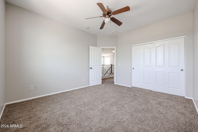 unfurnished bedroom with carpet, a closet, visible vents, a ceiling fan, and baseboards