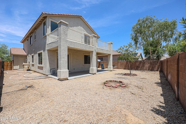 rear view of house featuring a patio, a fenced backyard, a tiled roof, and stucco siding