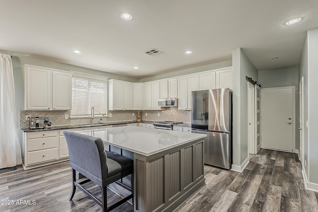 3062 E Cullumber St, Gilbert, AZ 85234 - kitchen with stainless steel appliances, dark wood-style flooring, a center island, backsplash, and recessed lighting
