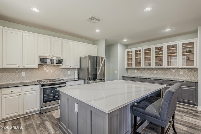 3062 E Cullumber St, Gilbert, AZ 85234 - kitchen featuring appliances with stainless steel finishes, a center island, backsplash, dark wood-style floors, and white cabinetry