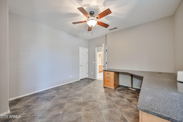 unfurnished office featuring a ceiling fan and baseboards