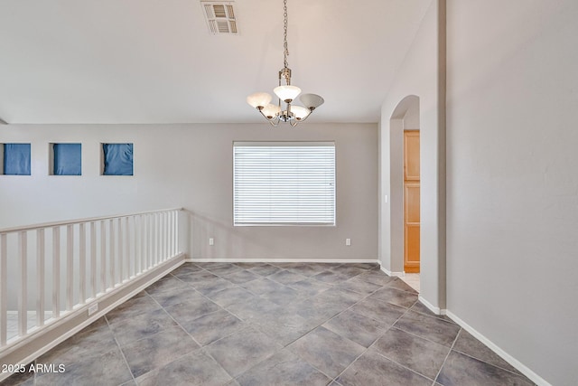 unfurnished dining area featuring a chandelier, arched walkways, and baseboards