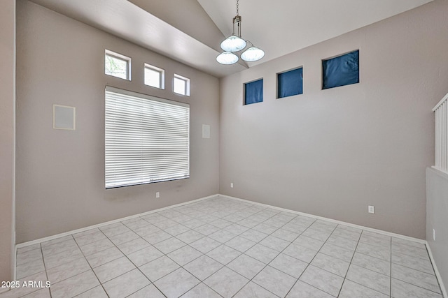 spare room with a chandelier, light tile patterned flooring, lofted ceiling, and baseboards