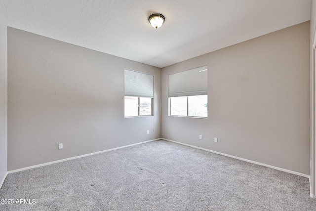 carpeted spare room with baseboards