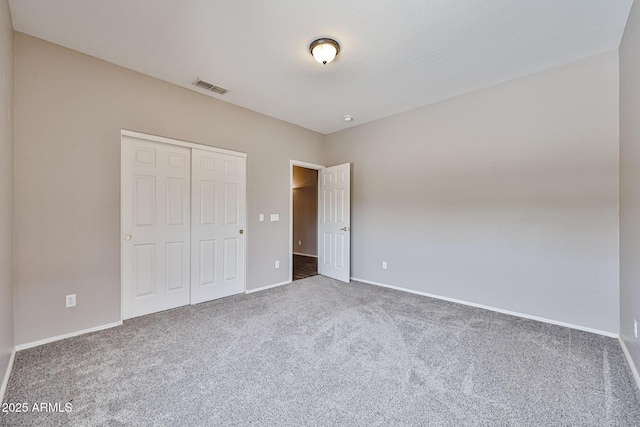 unfurnished bedroom with carpet, a closet, and baseboards