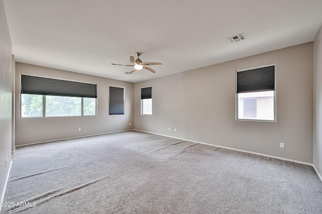 carpeted empty room featuring a ceiling fan and baseboards