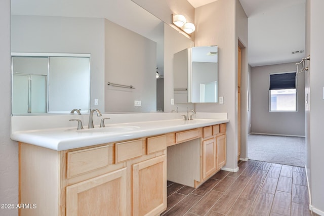 bathroom featuring wood finished floors, double vanity, and baseboards