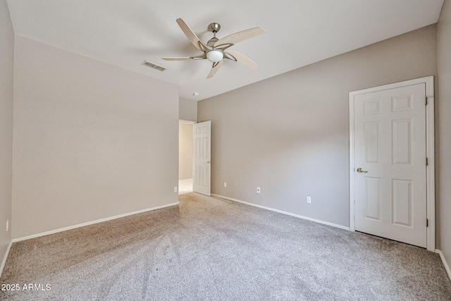 empty room with carpet flooring, a ceiling fan, and baseboards