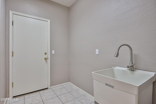 laundry room featuring a sink and baseboards