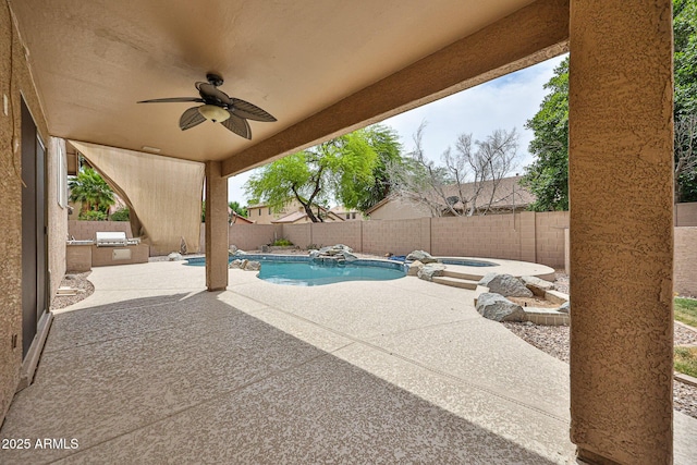 view of patio with exterior kitchen, a fenced backyard, a ceiling fan, and an in-ground hot tub