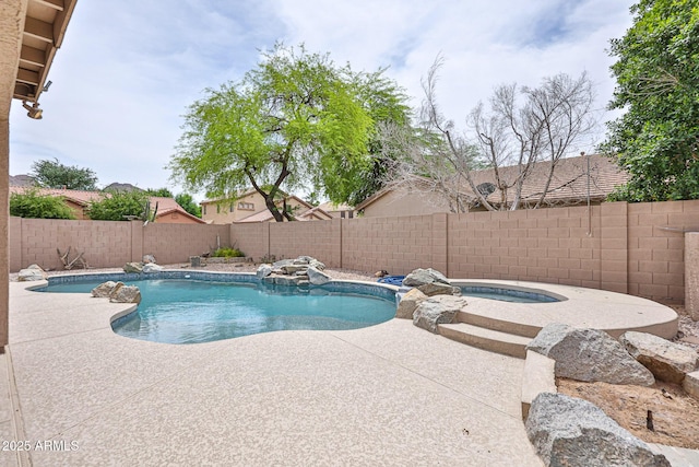 view of swimming pool with an in-ground hot tub, a patio area, and a fenced backyard