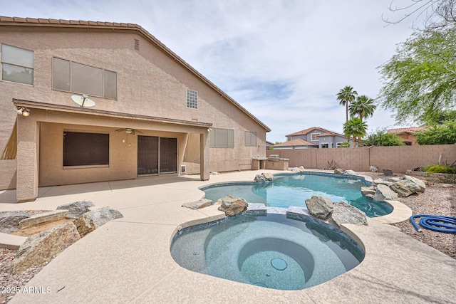 view of pool featuring a patio, a pool with connected hot tub, a fenced backyard, and a ceiling fan