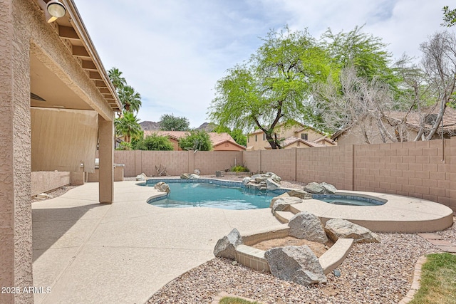 view of swimming pool with an in-ground hot tub, a patio, and a fenced backyard