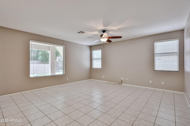 empty room featuring ceiling fan, baseboards, and light tile patterned flooring