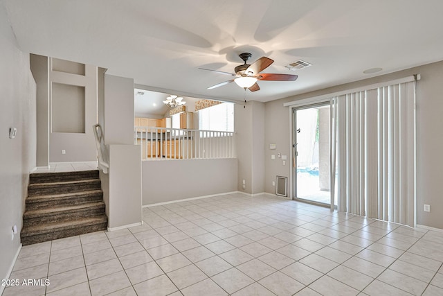 unfurnished room with healthy amount of natural light, ceiling fan, light tile patterned floors, and a chandelier