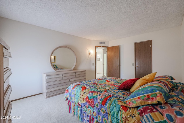 bedroom with a textured ceiling and light colored carpet