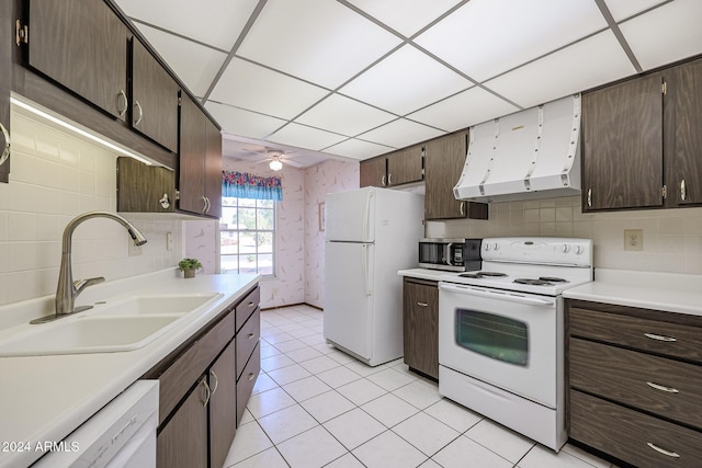 kitchen with dark brown cabinetry, ceiling fan, sink, white appliances, and light tile patterned flooring