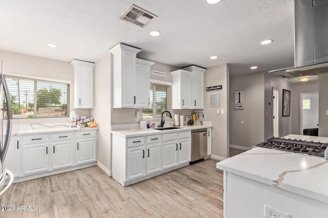 kitchen featuring white cabinetry, dishwasher, sink, and light wood-type flooring