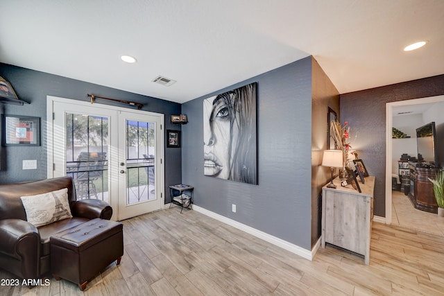 sitting room with light hardwood / wood-style flooring and french doors