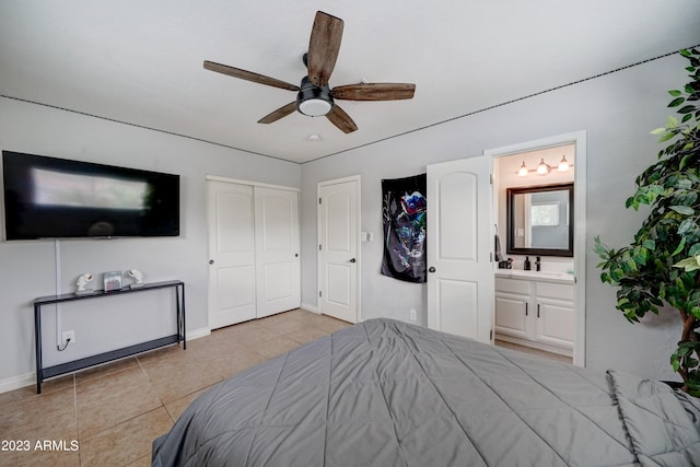 bedroom featuring a closet, ensuite bath, light tile patterned floors, and ceiling fan