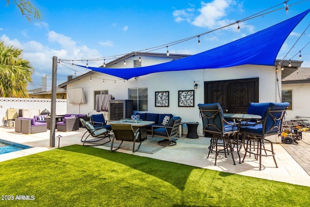 back of property with a patio, a lawn, and an outdoor hangout area