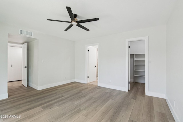 6629 N Majorca Way E, Phoenix, AZ 85016 - unfurnished bedroom featuring light wood-type flooring, a spacious closet, baseboards, a closet, and ceiling fan