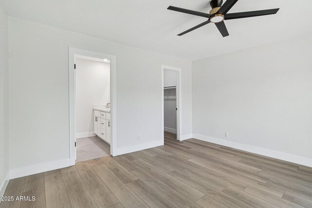 6629 N Majorca Way E, Phoenix, AZ 85016 - unfurnished bedroom featuring light wood finished floors, a spacious closet, baseboards, a closet, and ensuite bath