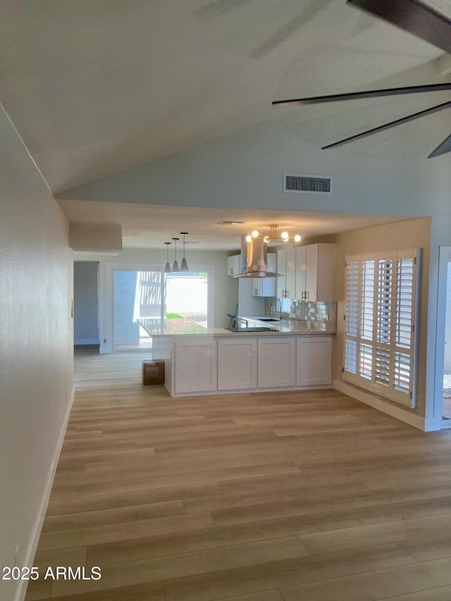 6629 N Majorca Way E, Phoenix, AZ 85016 - kitchen featuring white cabinets, vaulted ceiling, exhaust hood, a peninsula, and baseboards