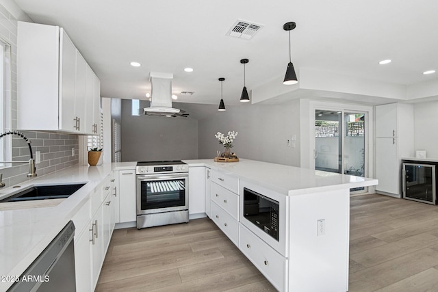 6629 N Majorca Way E, Phoenix, AZ 85016 - kitchen featuring appliances with stainless steel finishes, island exhaust hood, beverage cooler, a sink, and light wood-style flooring