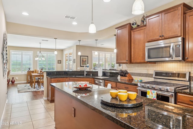 33305 N 26th Ave, Phoenix, AZ 85085 - kitchen featuring appliances with stainless steel finishes, a peninsula, brown cabinets, healthy amount of natural light, and recessed lighting